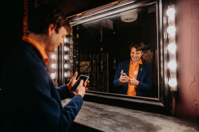 Neven backstage beside an illuminated dressing-room mirror