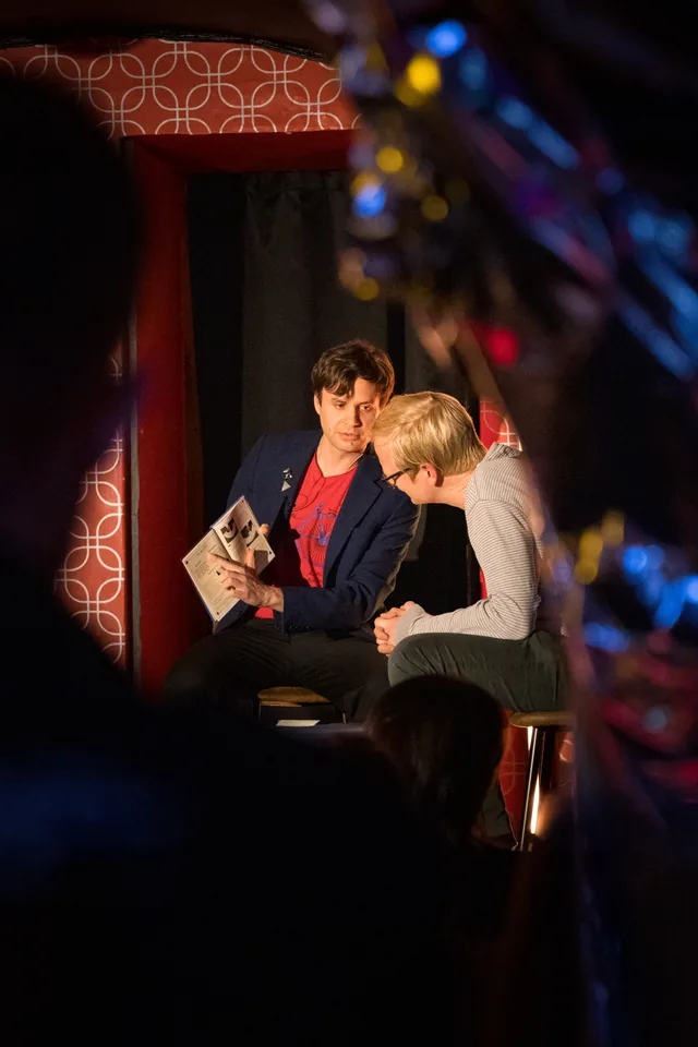 Neven performing a book trick with an audience volunteer